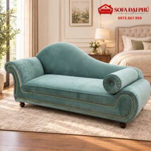 Góc chụp xéo chiếc ghế sofa nằm thư giãn tân cổ điển màu xanh mint nhung đi kèm gối ôm tròn rút múi